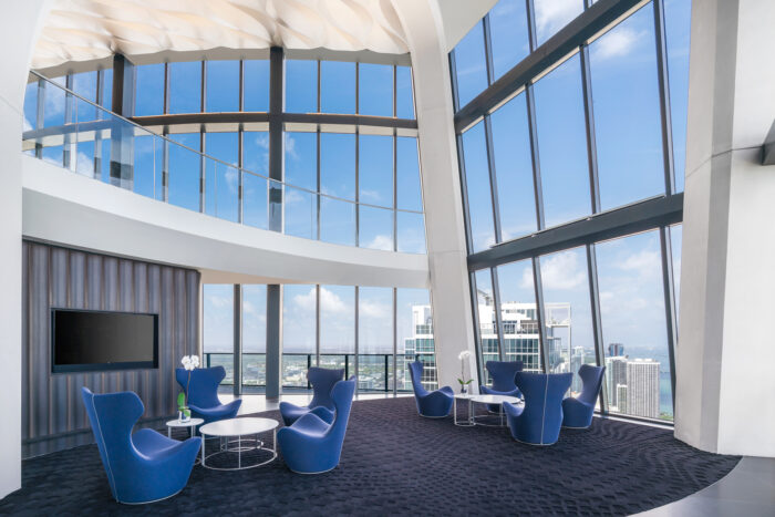 Sky lounge στο One Thousand Museum Miami με μεγάλα υαλοστάσια και πανοραμική θέα, παράδειγμα σύγχρονης αρχιτεκτονικής και υβριδικού χώρου