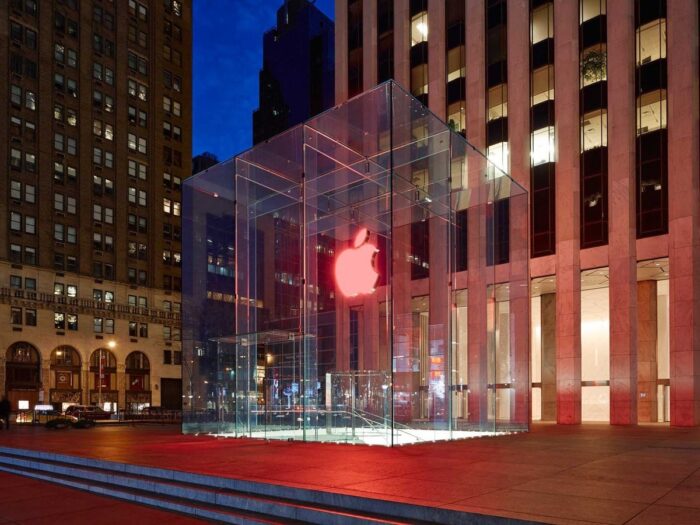 Φωτισμένη γυάλινη facade Apple Store τη νύχτα με σύγχρονο αρχιτεκτονικό σχεδιασμό