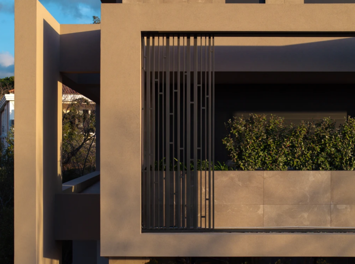 Modern facade εισόδου συγκροτήματος κατοικιών με αρχιτεκτονικό φωτισμό και κάθετο κήπο